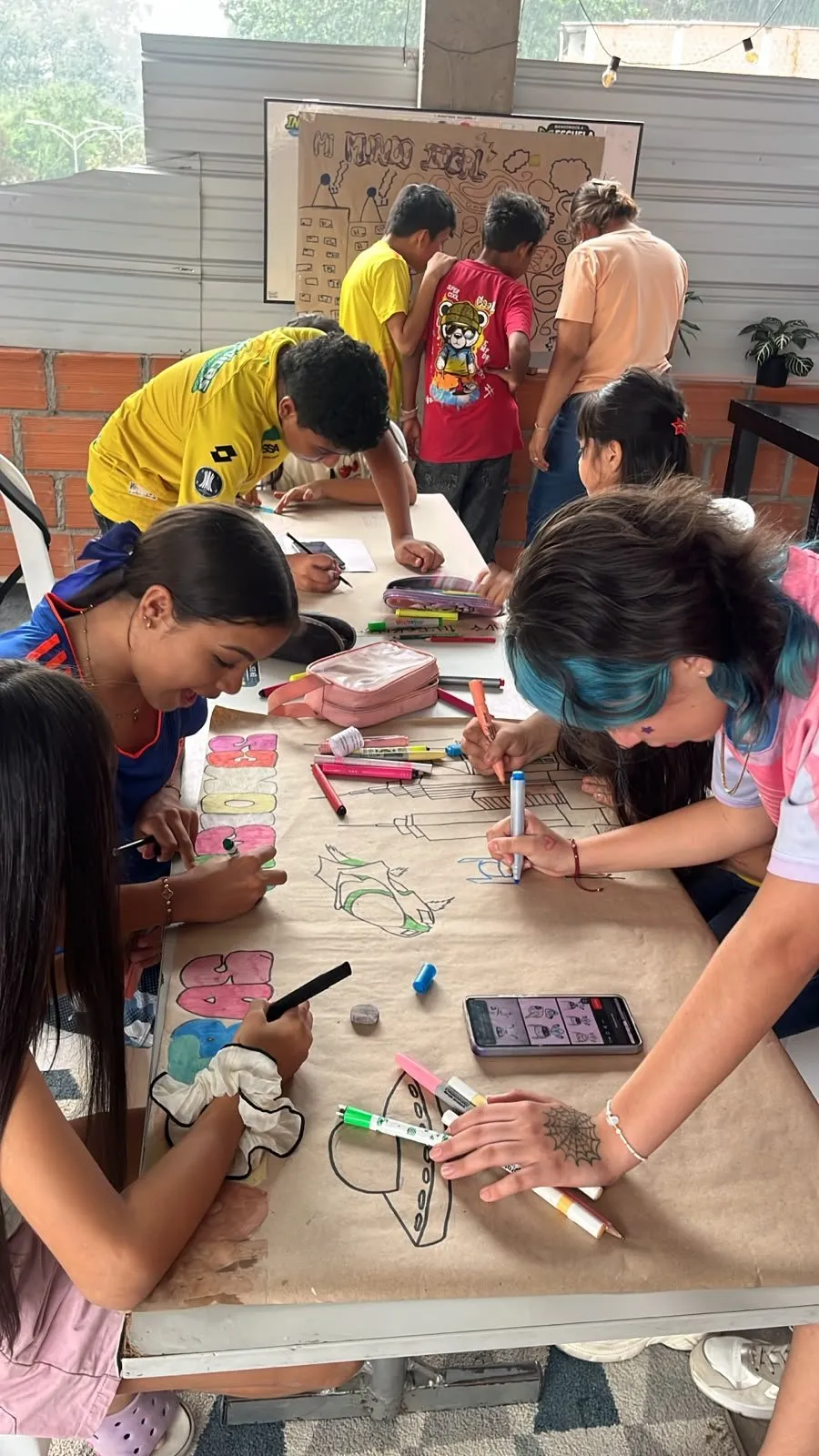 La mesa larga, dibujando el mural entre todos
