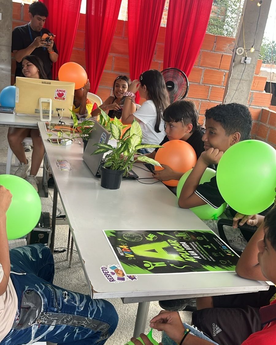 Niños trabajando en una mesa de la terraza, con globos de colores