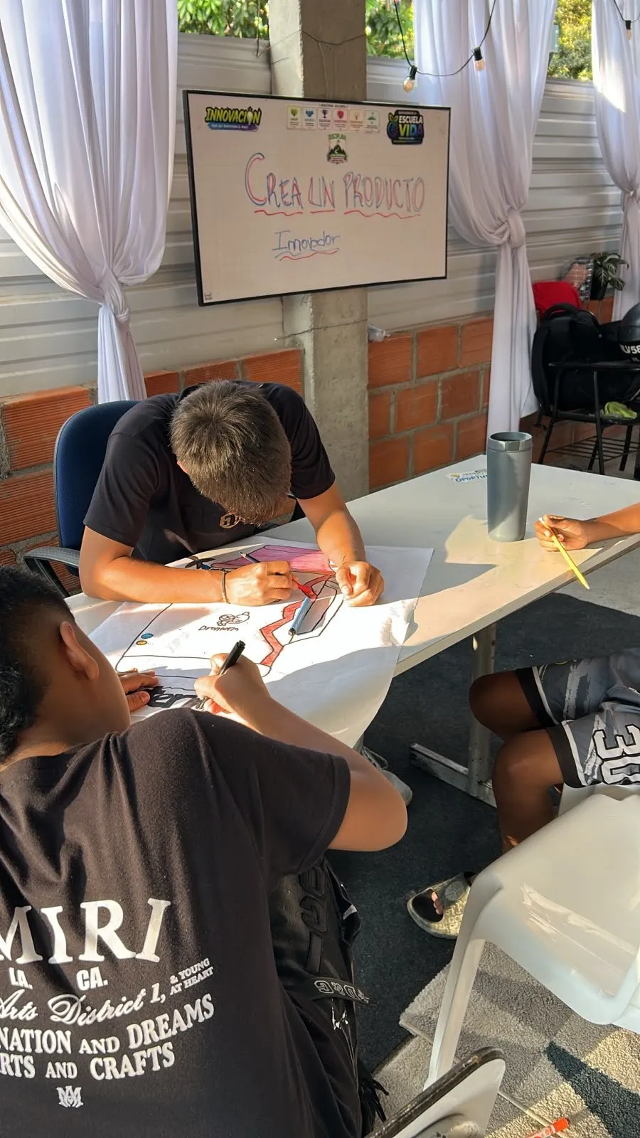 Dos estudiantes colorean el dibujo del Dronterm