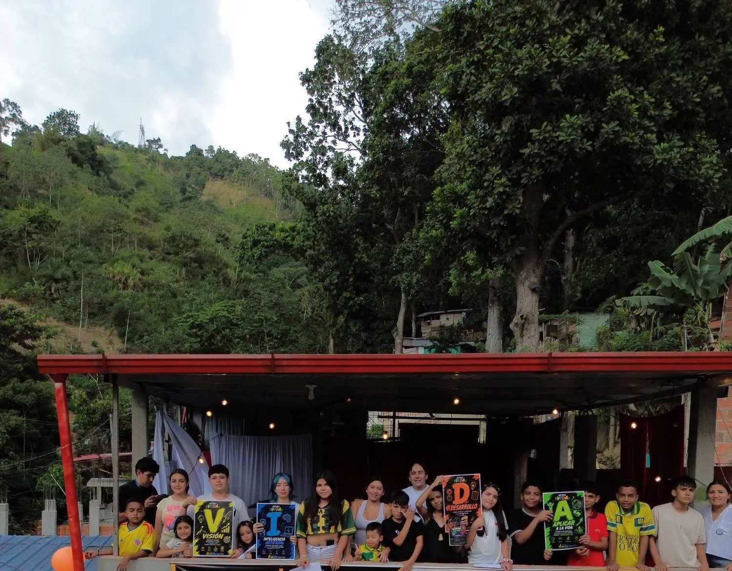 La terraza de Escuela VIDA en Asohelechales, con la ladera del barrio detrás