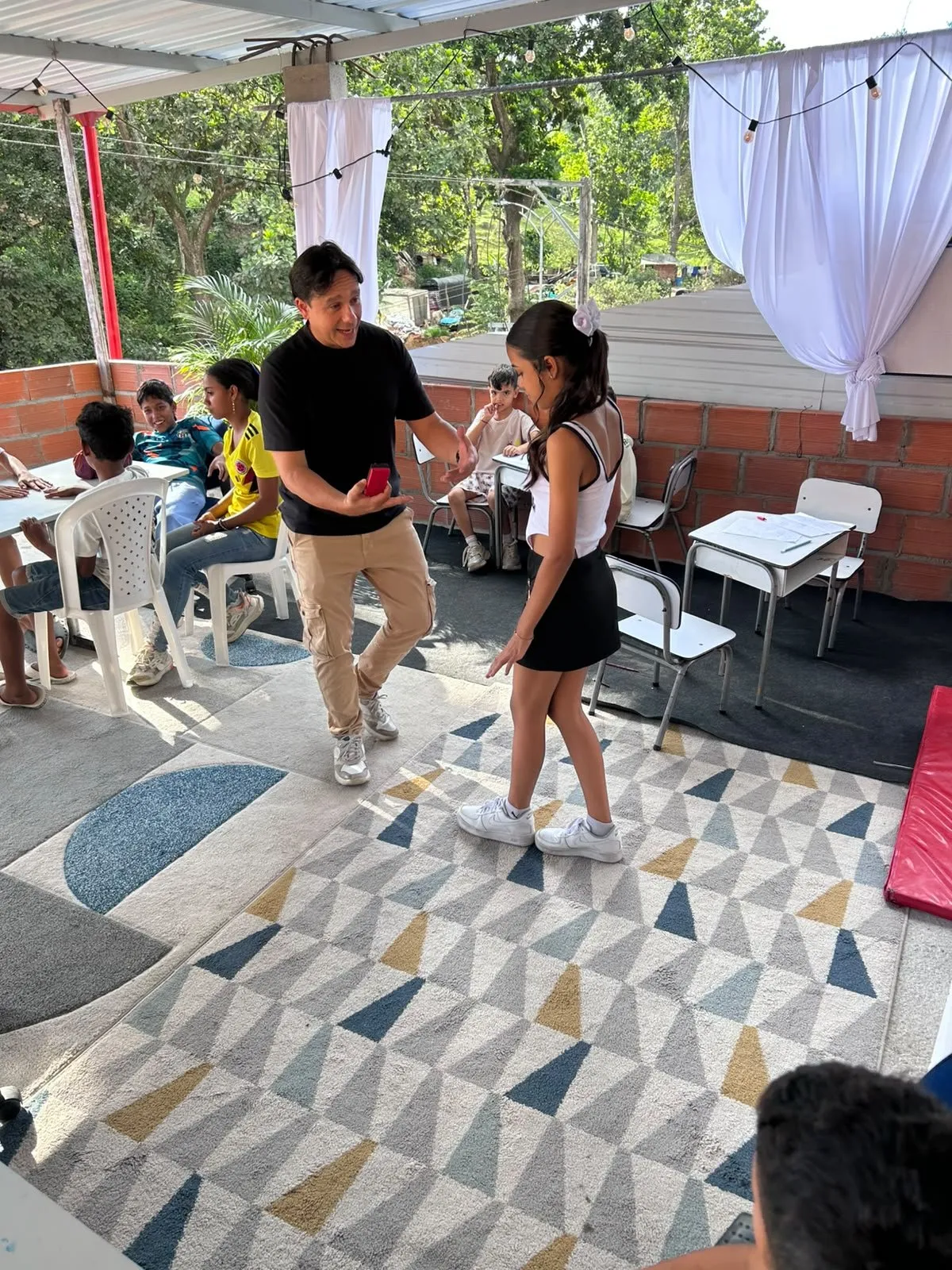 El profesor le explica una idea a una estudiante mientras el grupo escucha