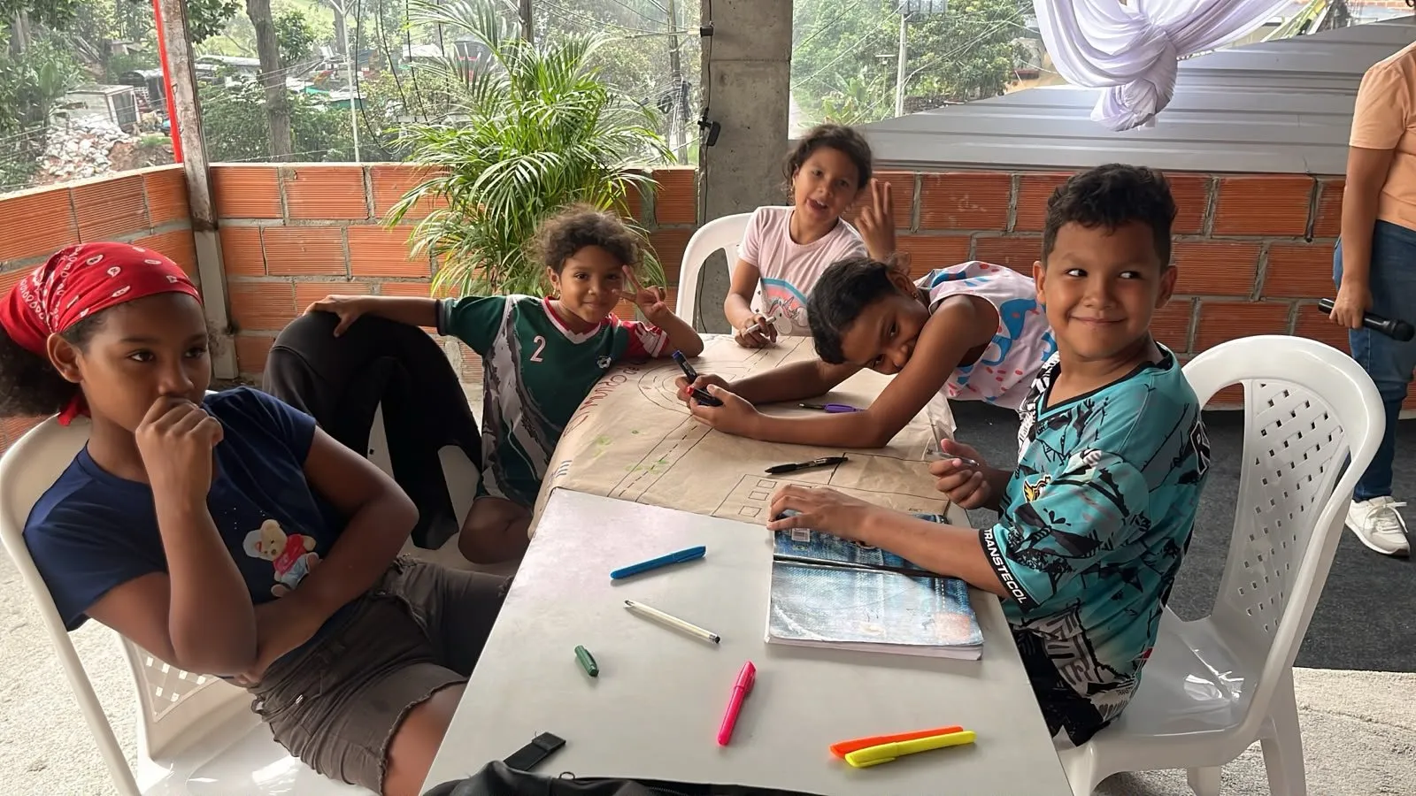 Los más pequeños dibujan con marcadores en una mesa de la terraza
