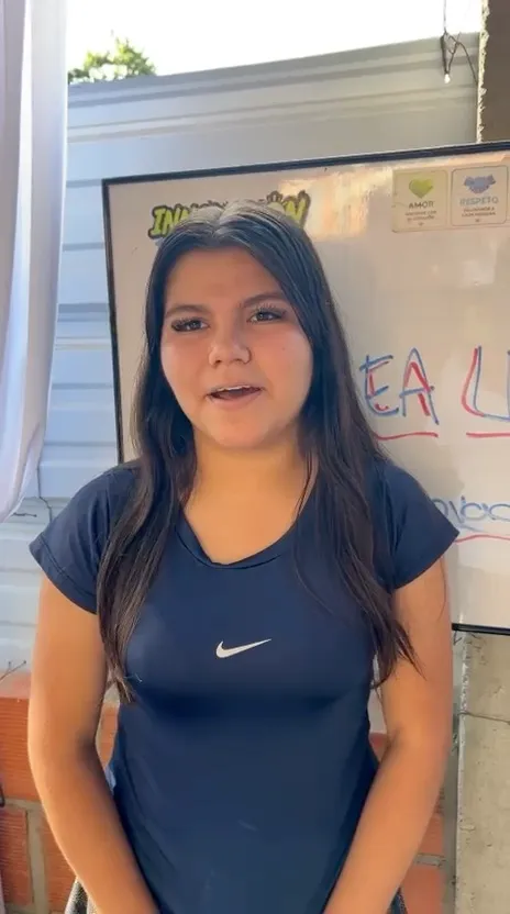 Una estudiante habla del taller frente al tablero